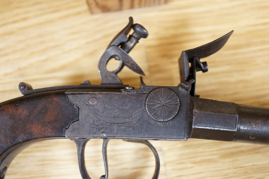 A double barrel flintlock, tap action pocket pistol by Collis of Oxford, with sliding top thumb safety, slab walnut grip, and tower private proof marks